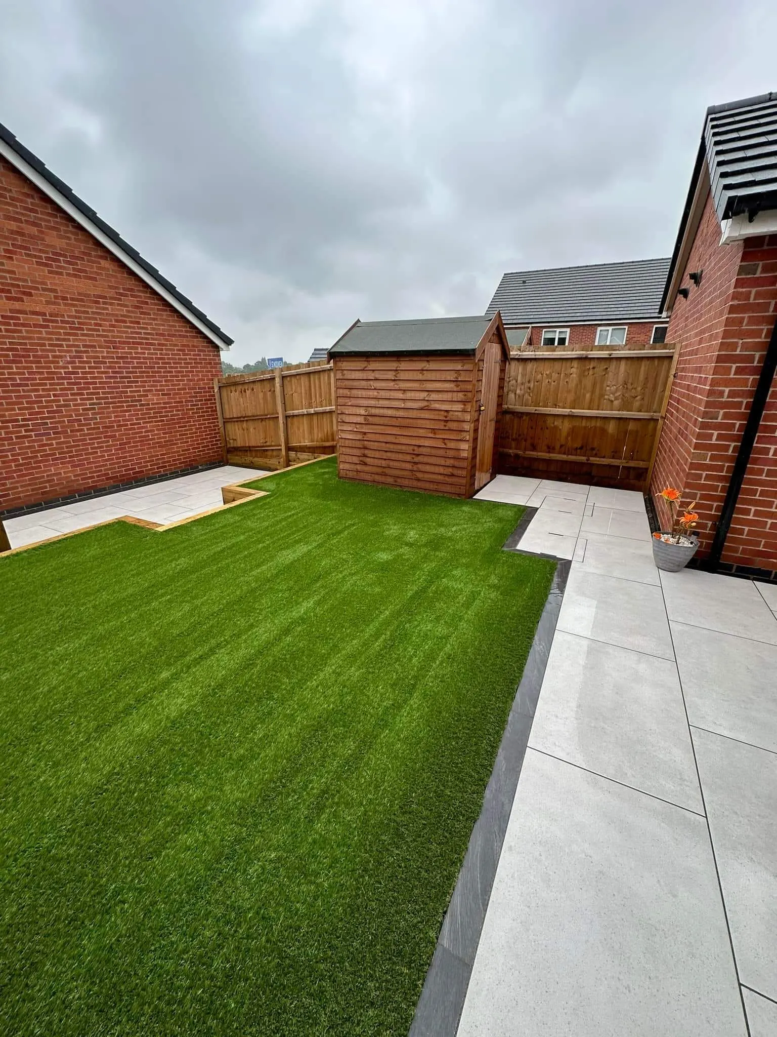 Artificial grass with a porcelain path in a new-build garden