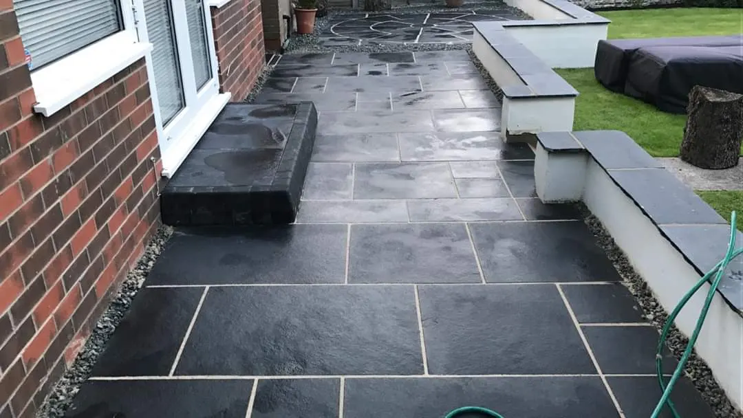 Black slate patio with rendered raised beds