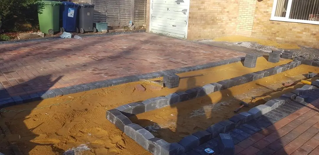 Block paving edging being laid on a sharp sand bed