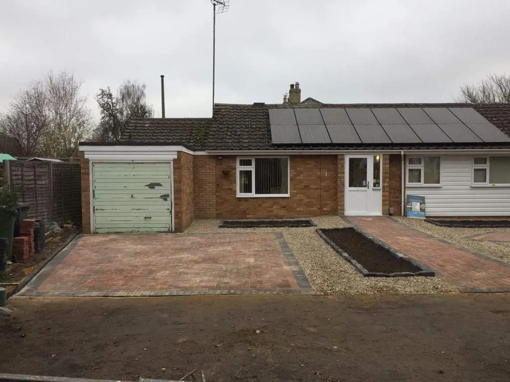 Block paving parking bay and gravel frontage at a bungalow with a garage