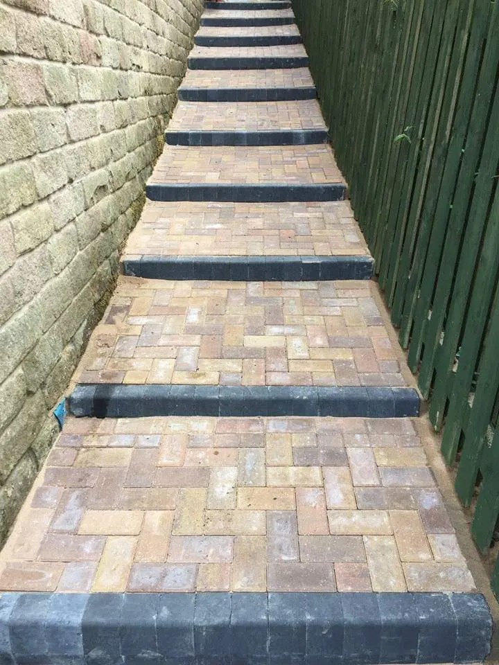 Block paving stepped path with charcoal nosings in a narrow side passage