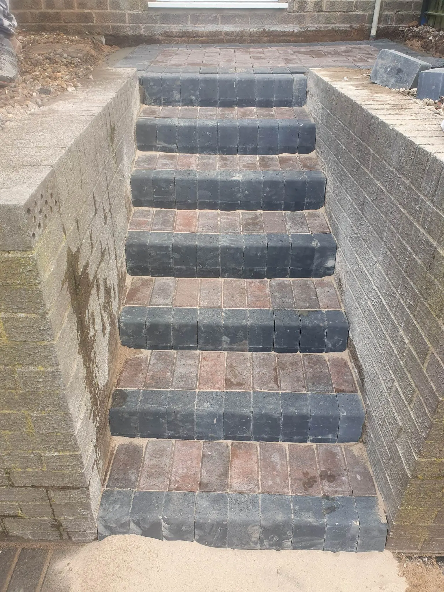 Block paving steps rising between brick walls