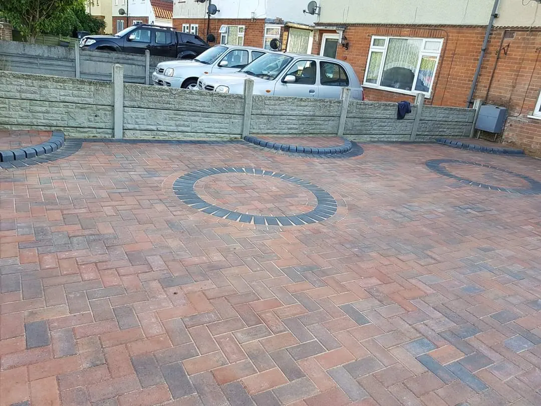 Brindle block paving with charcoal circle features in front of a terrace