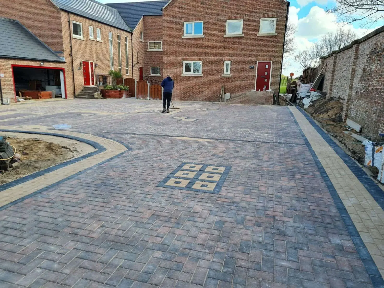 Large brindle block paving driveway with a buff border and a decorative inset