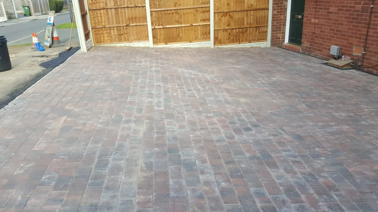 Brindle block paving driveway in front of a fenced house