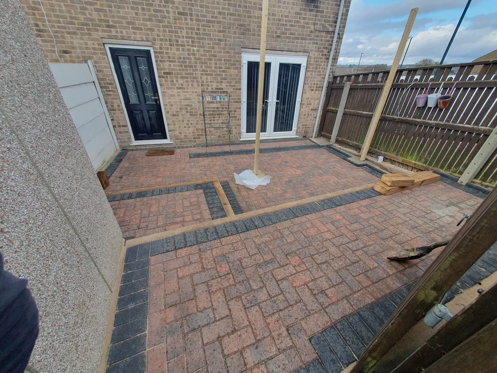 Brindle herringbone block paving garden with charcoal bands outside patio doors