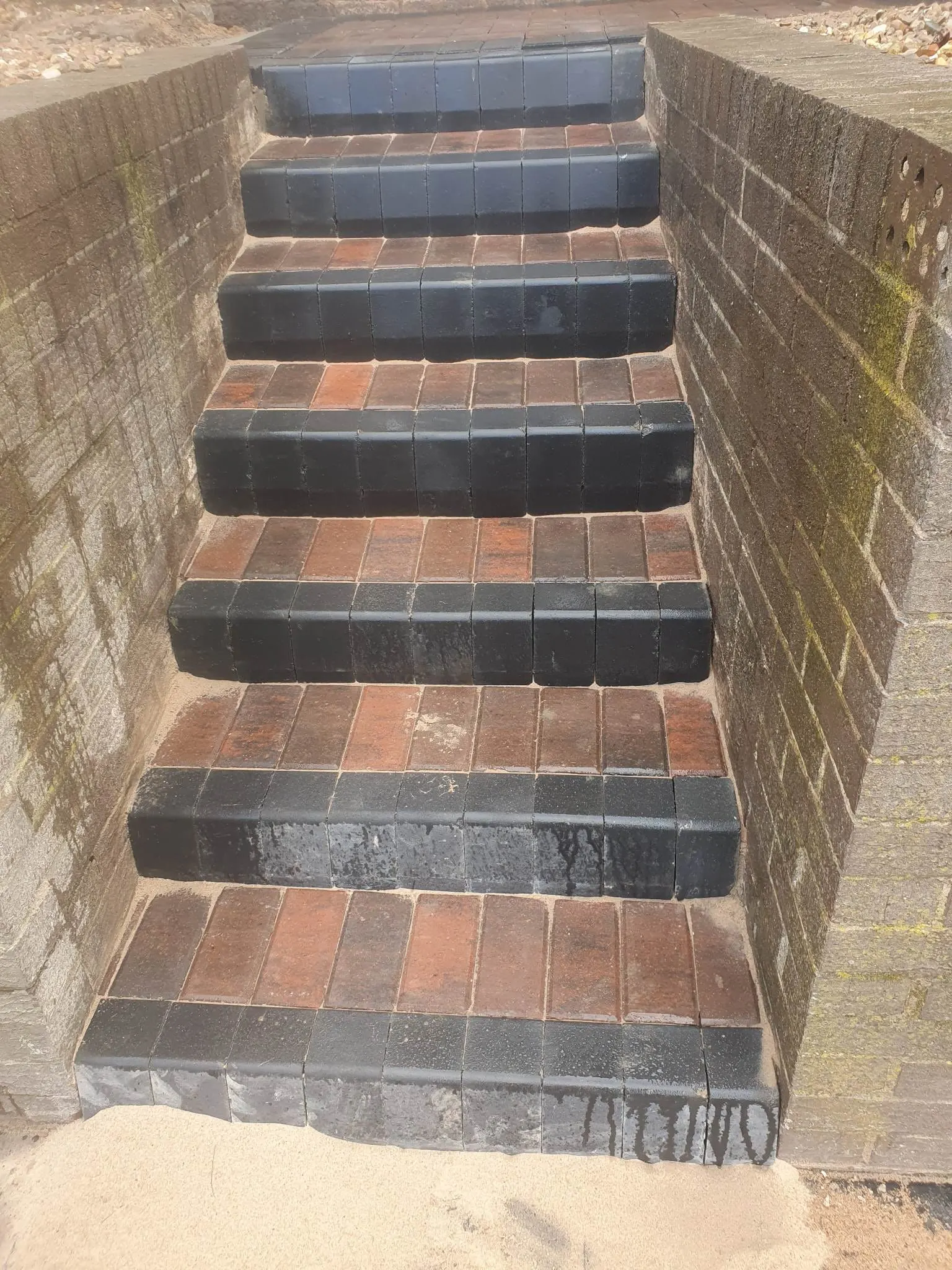 Brindle block paving steps with charcoal nosings between brick walls