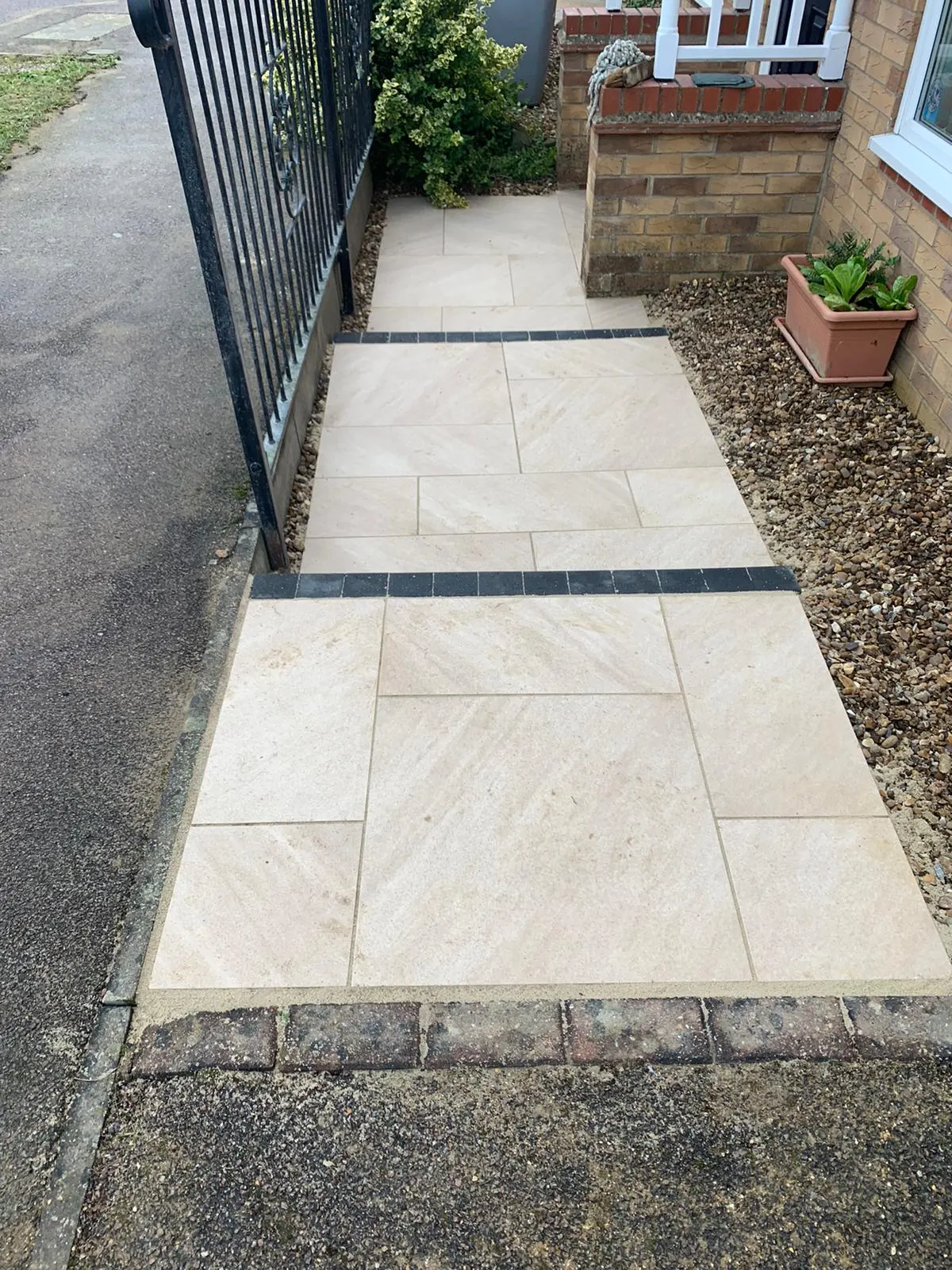 Buff porcelain front path with charcoal bands beside railings