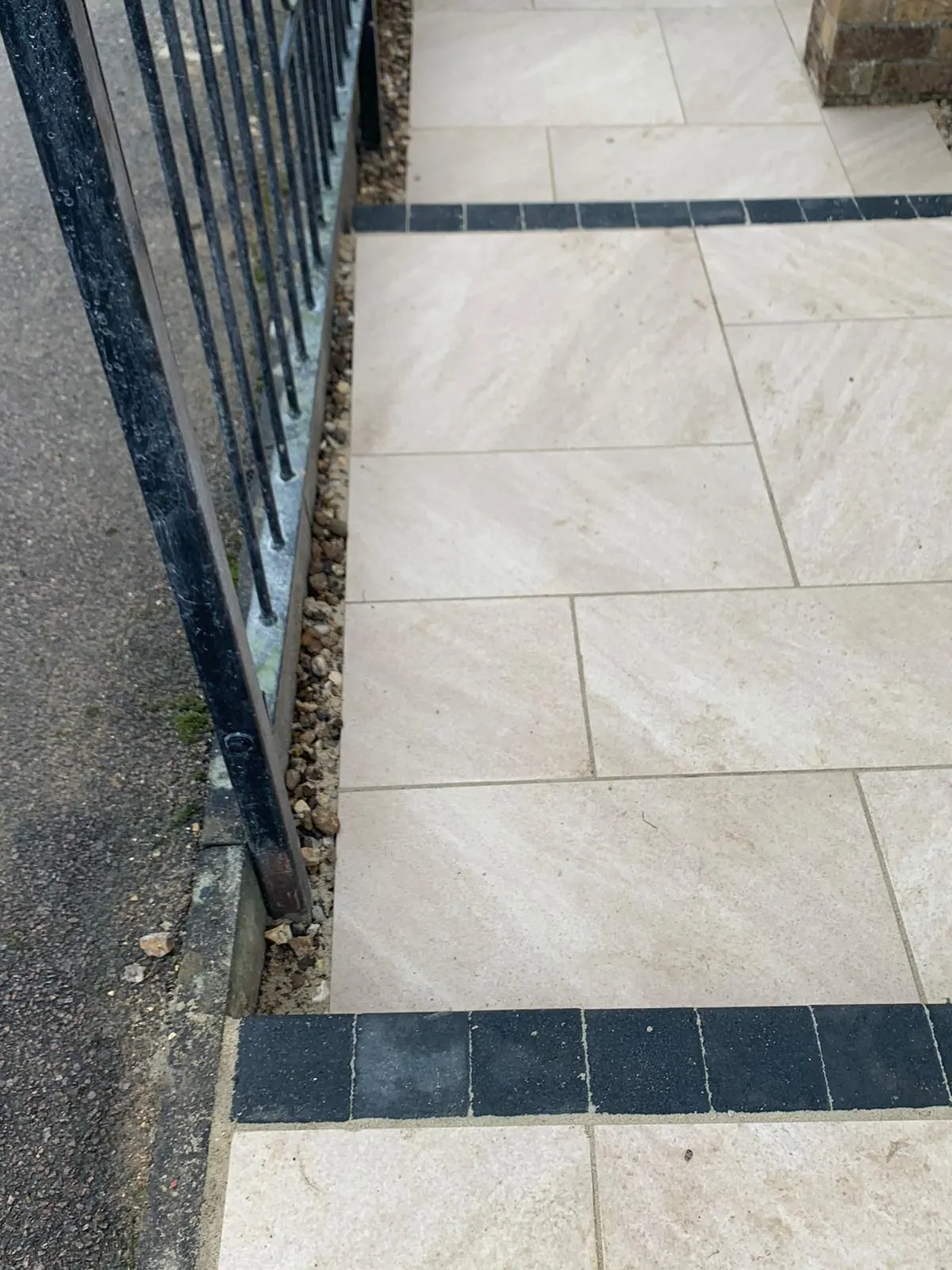 Buff porcelain path with a charcoal band beside railings