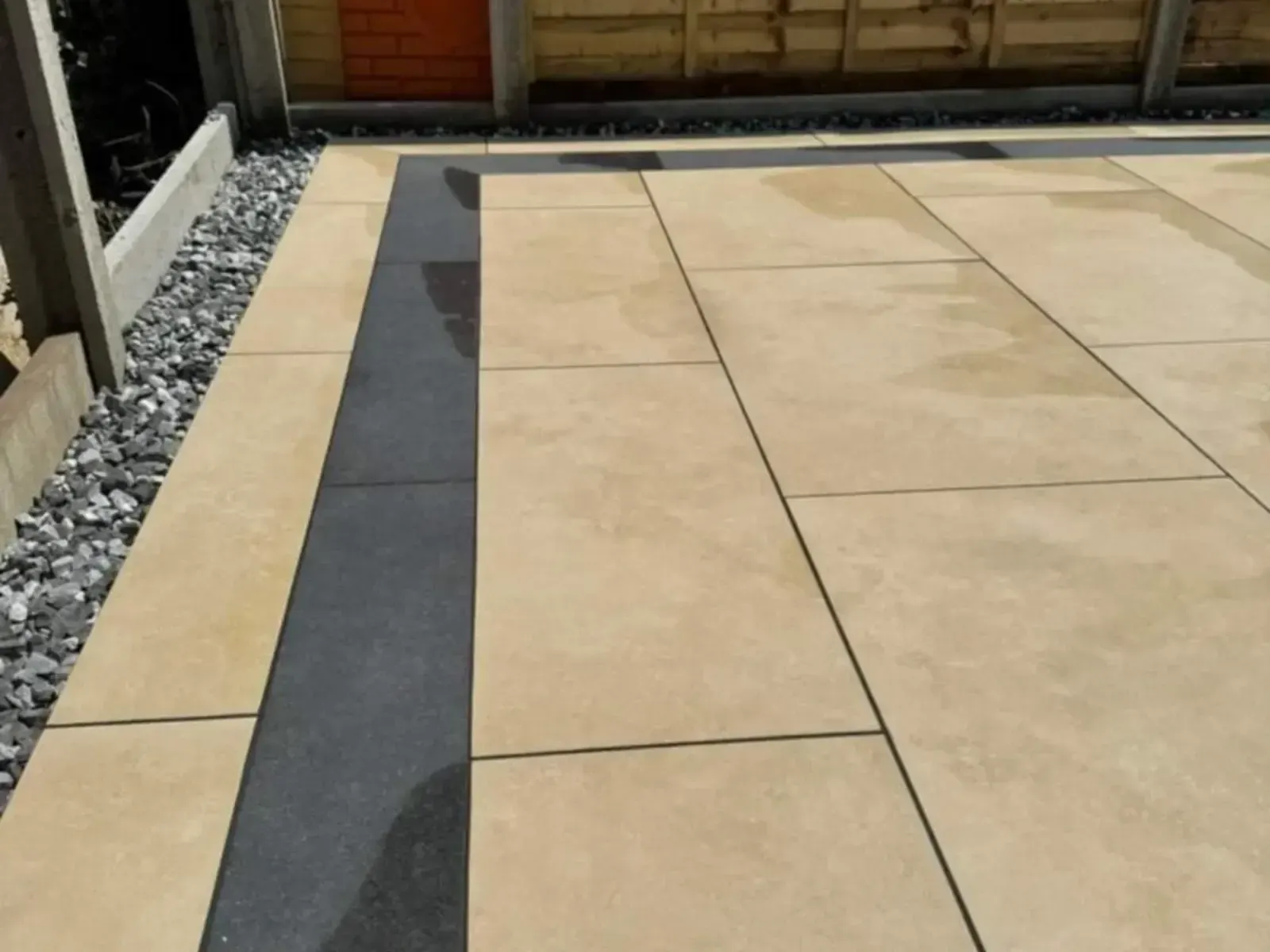 Buff porcelain patio slabs with a charcoal border strip