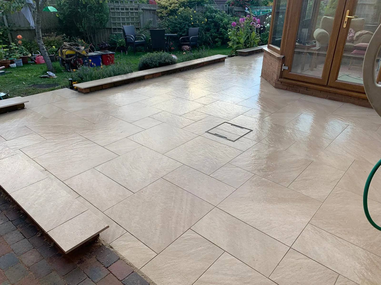 Buff porcelain patio with a step outside a conservatory