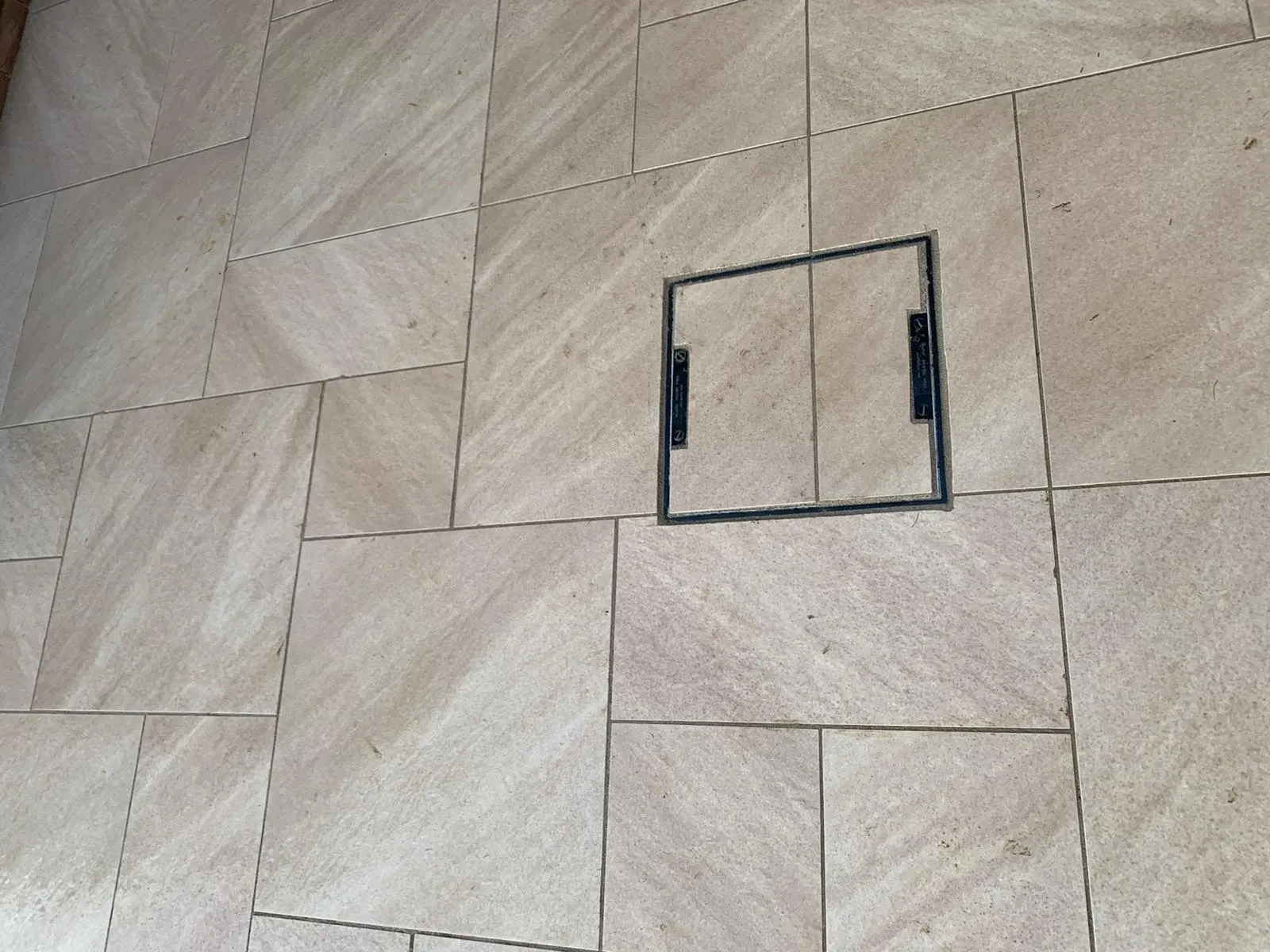 Buff porcelain patio with a recessed access cover