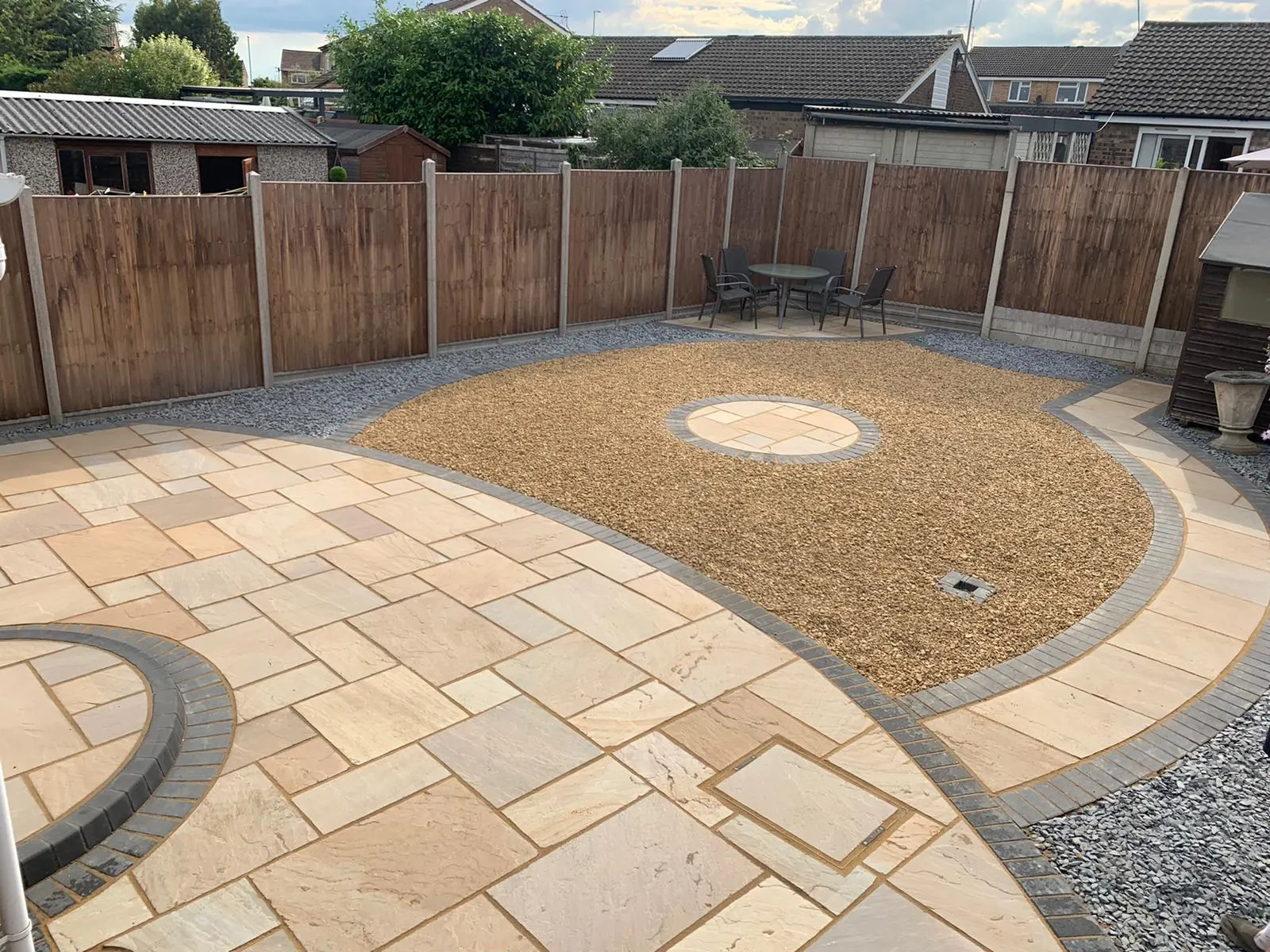 Buff sandstone patio with curved borders around a gravel bed