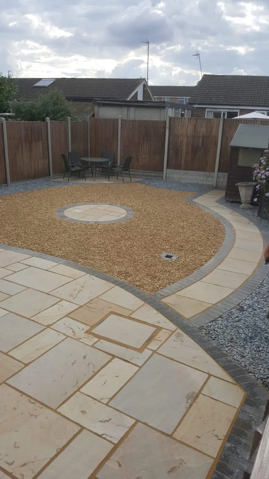 Buff sandstone patio with a curved border and a gravel circle