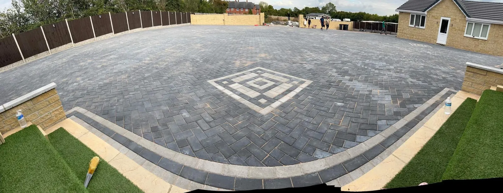 Large charcoal block paving courtyard with a buff diamond feature