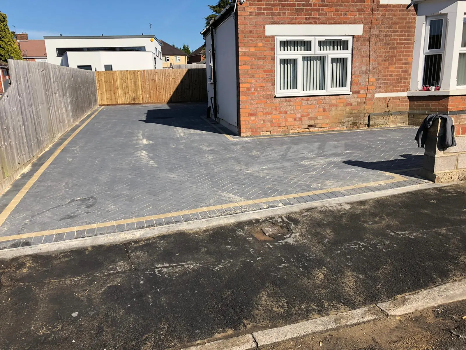 Charcoal block paving driveway with a buff border line
