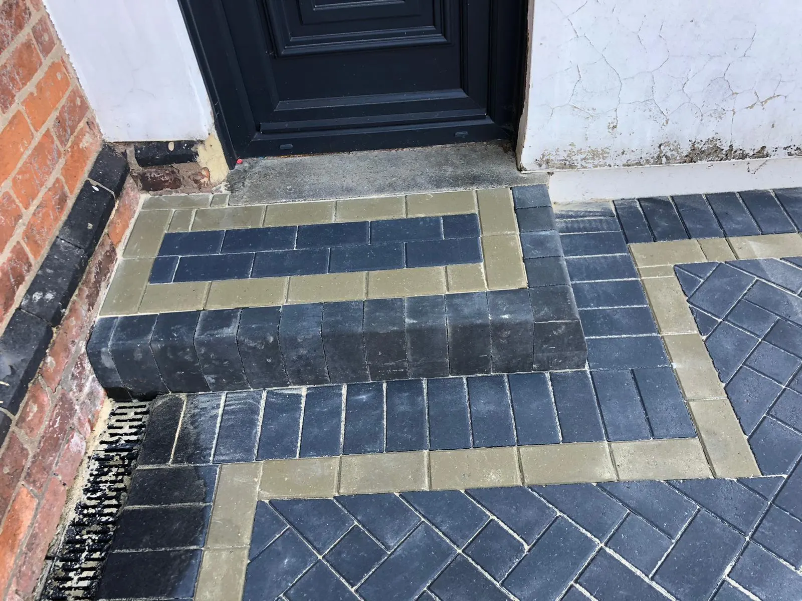Charcoal block paving front step with a buff border