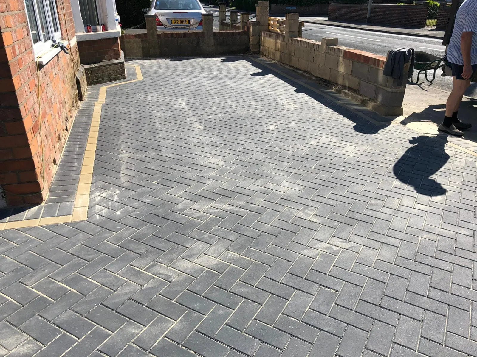 Charcoal herringbone block paving driveway with buff edging
