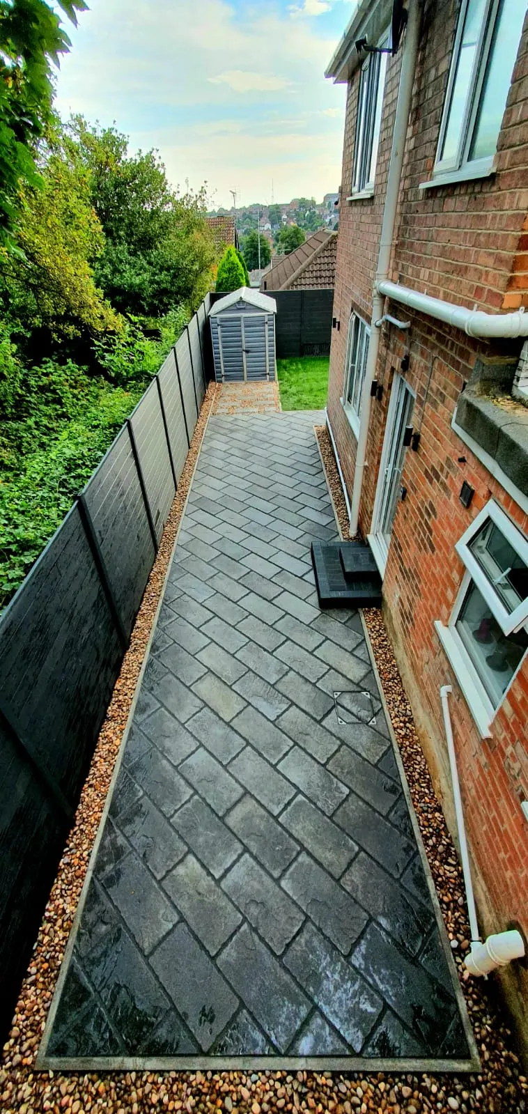 Charcoal block paving path in herringbone down the side of a house