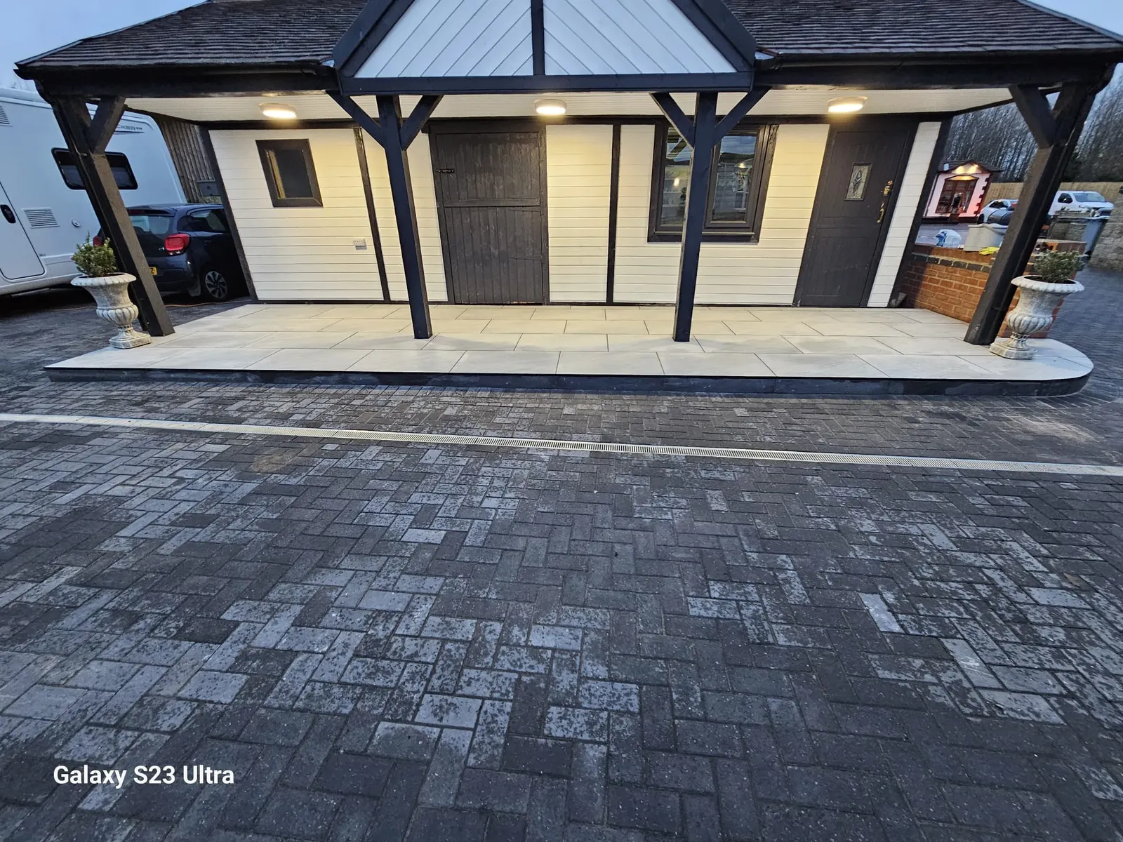 Charcoal block paving in front of a veranda with a porcelain floor