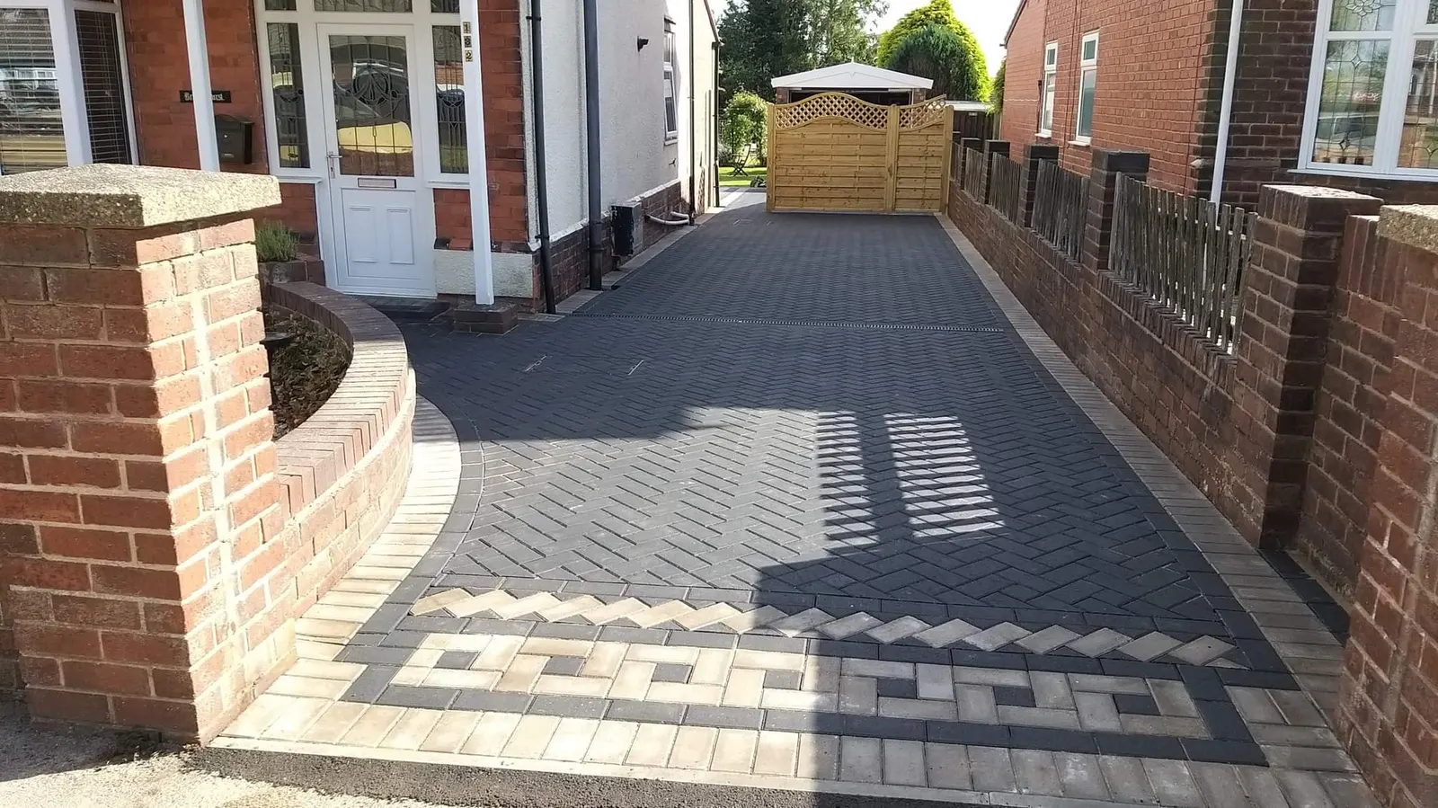Charcoal herringbone block paving path with a Greek key border