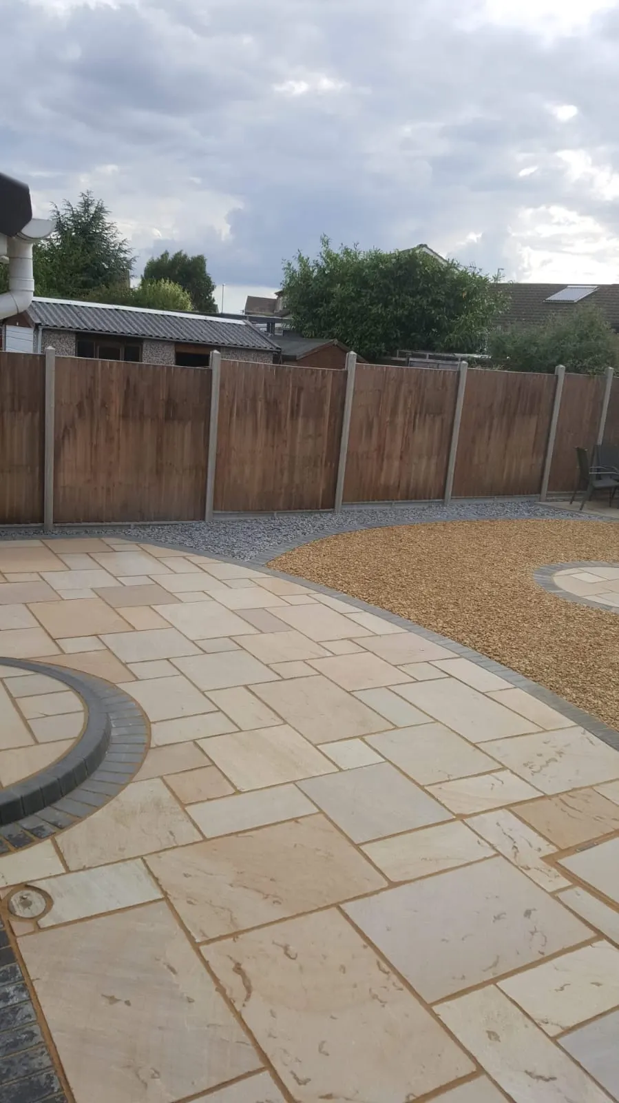 Curved buff sandstone patio around a gravel circle