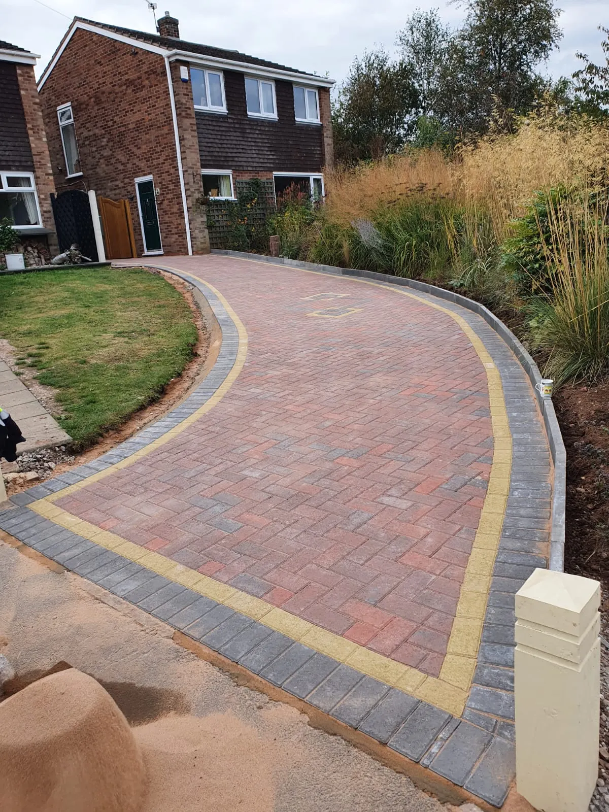 Curved red block paving driveway with buff and charcoal borders