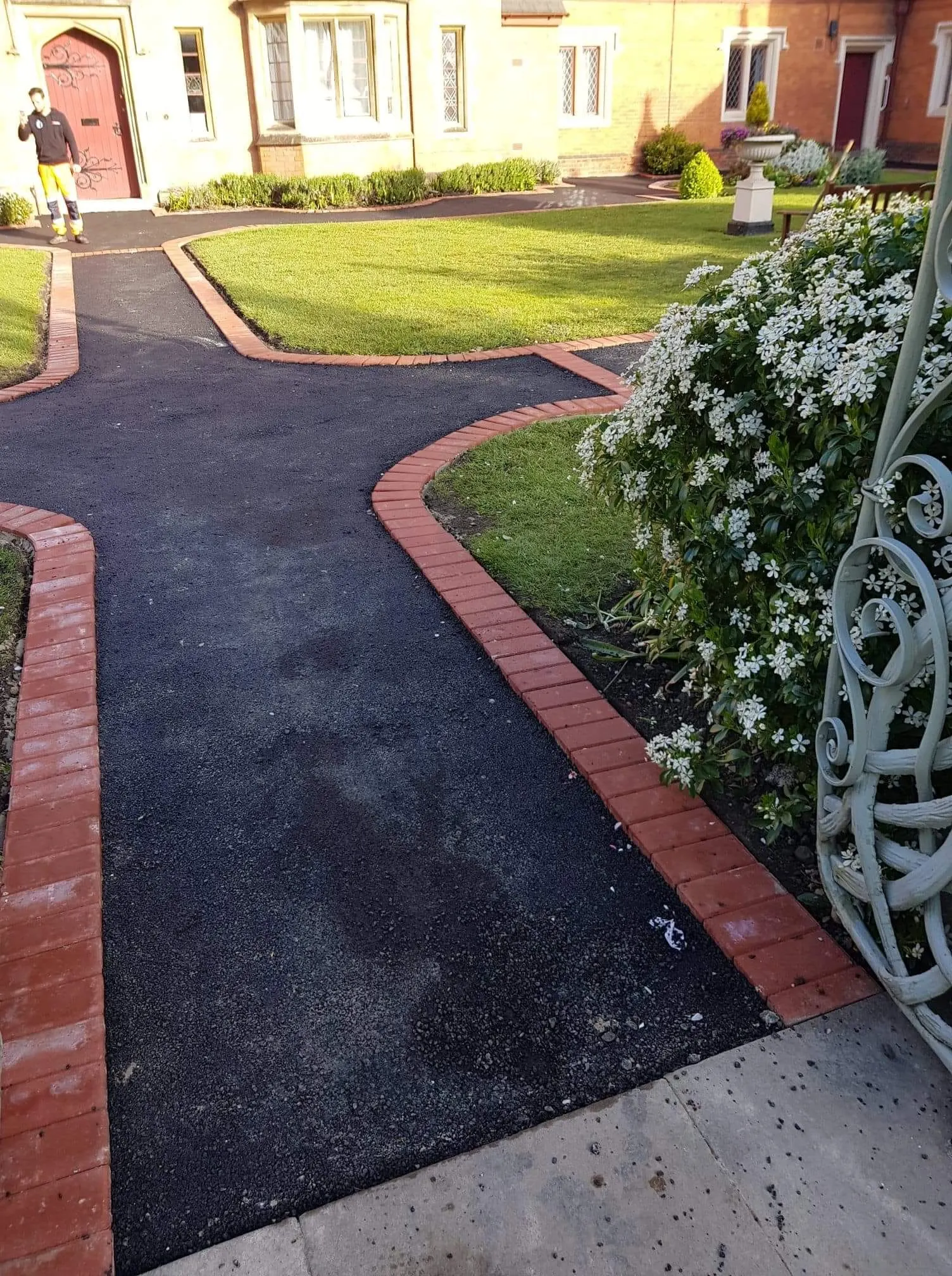 Curved tarmac path with red block paving edging