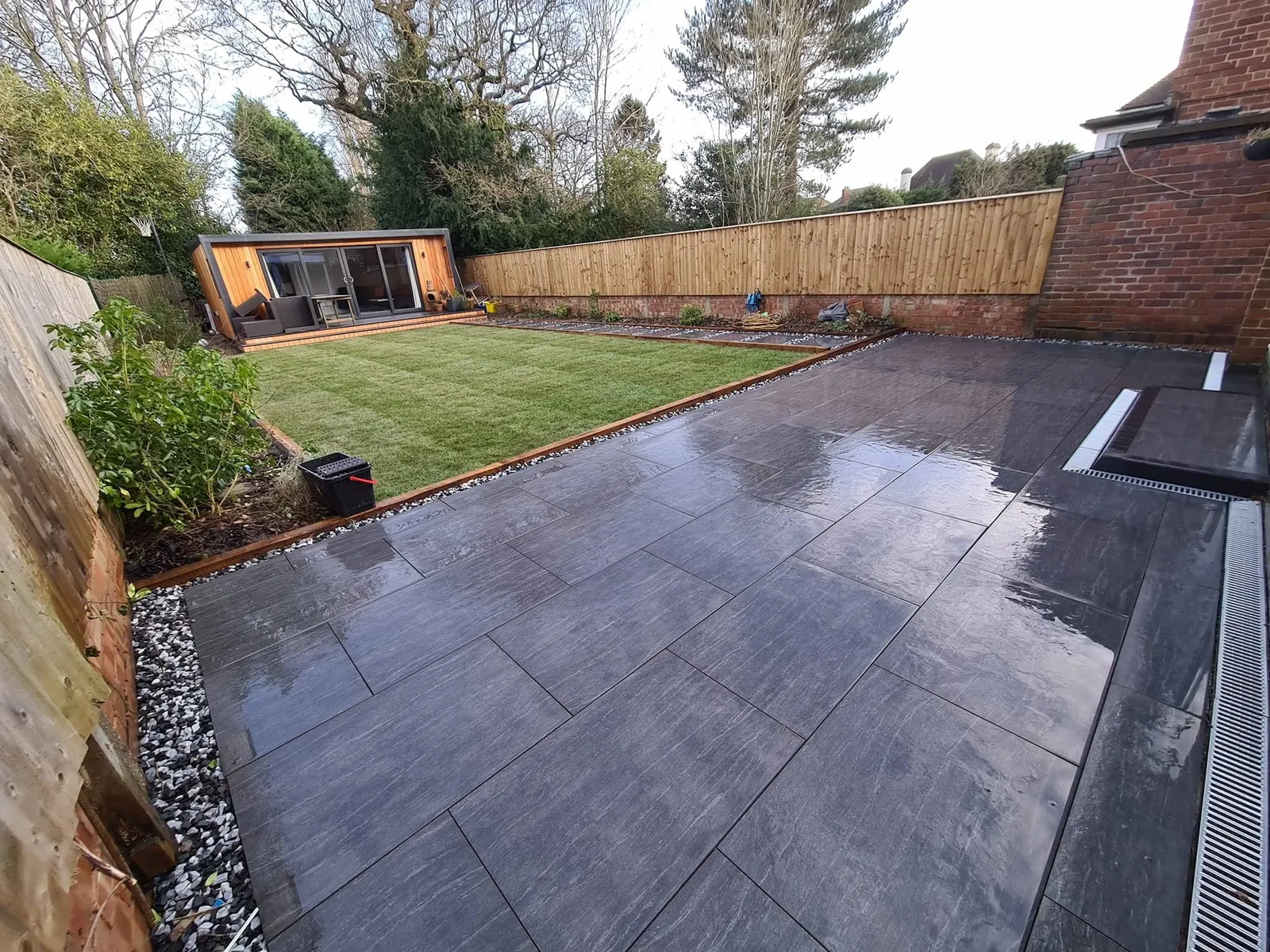 Dark porcelain patio and lawn in front of a garden room