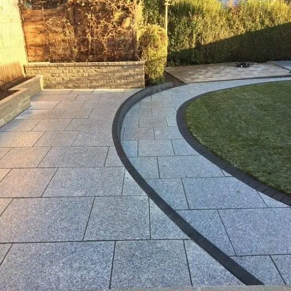 Granite-effect porcelain path curving round a lawn