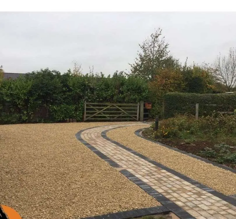 Gravel driveway with a cobble block path to a field gate