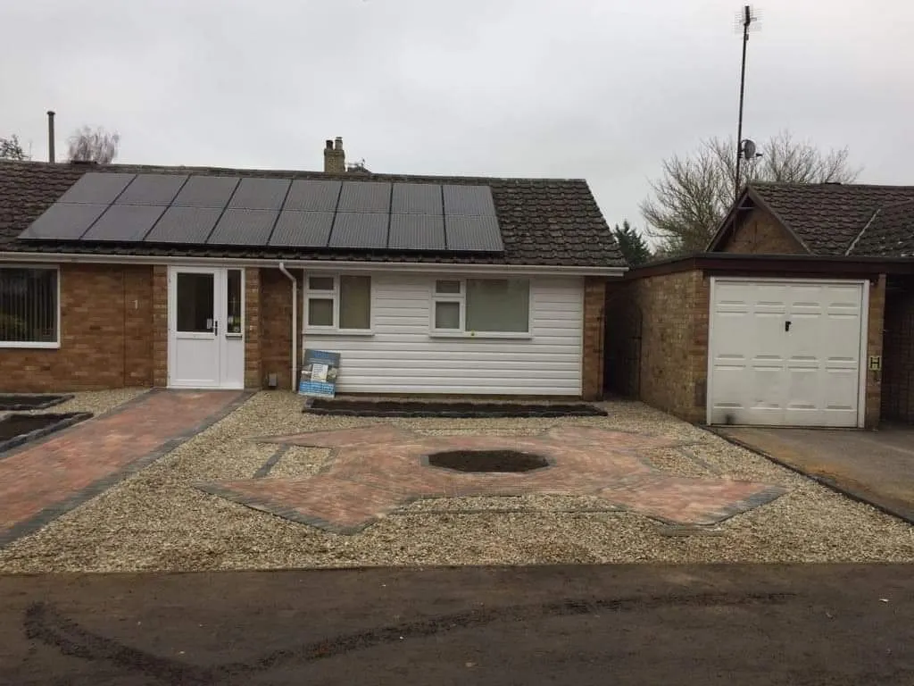 Gravel frontage with a block paving feature and planting beds at a bungalow