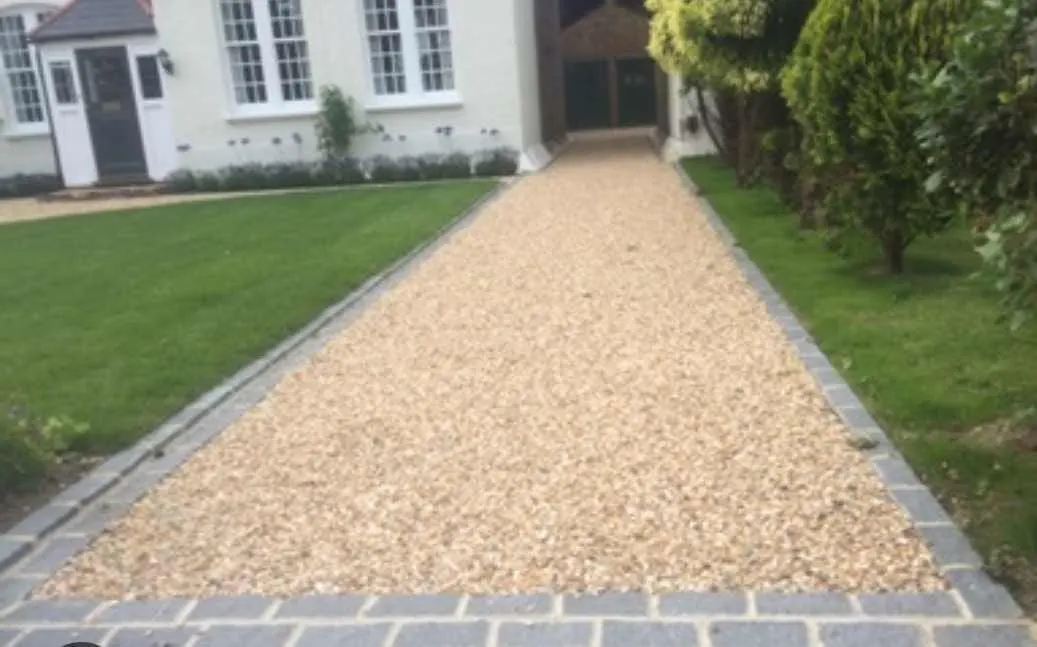 Gravel path with block paving edging beside a lawn