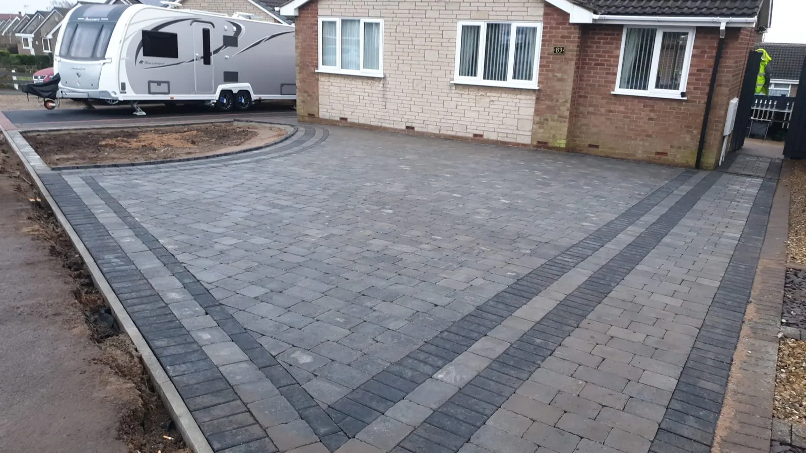 Grey block paving driveway with charcoal bands