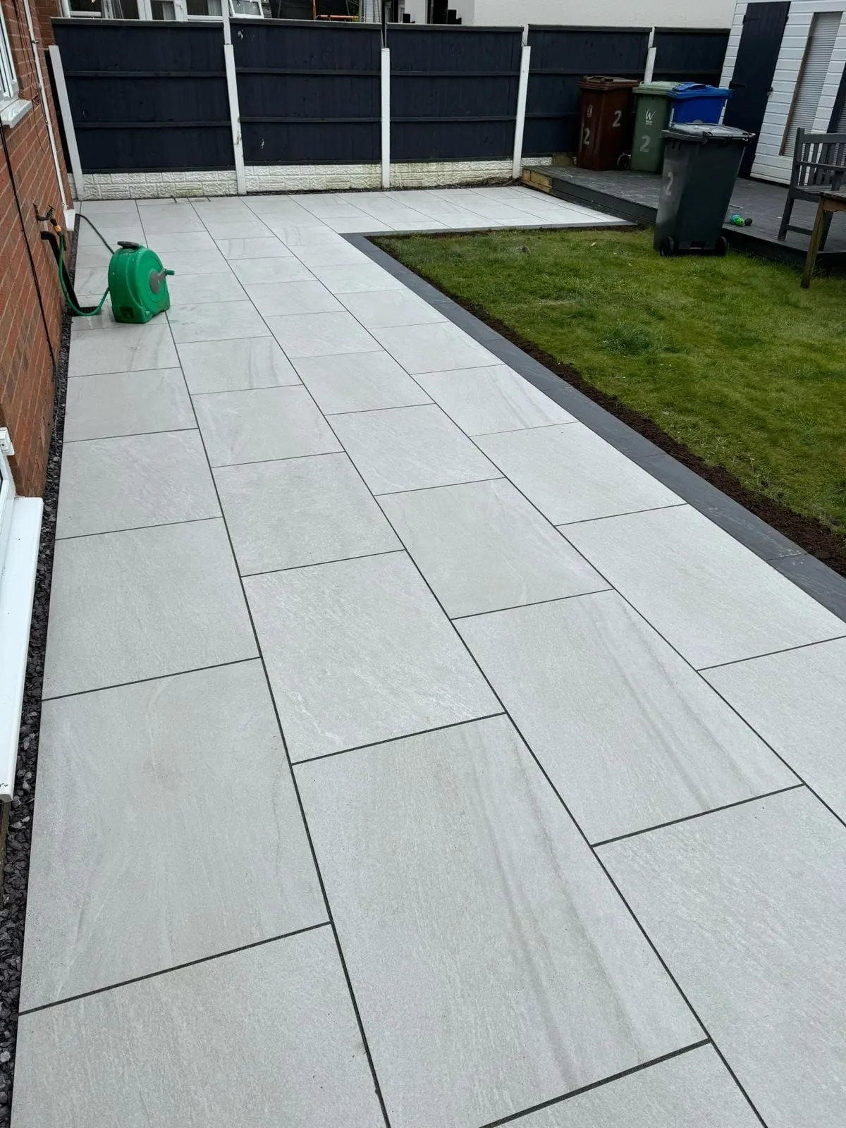 Wide grey porcelain path beside a lawn