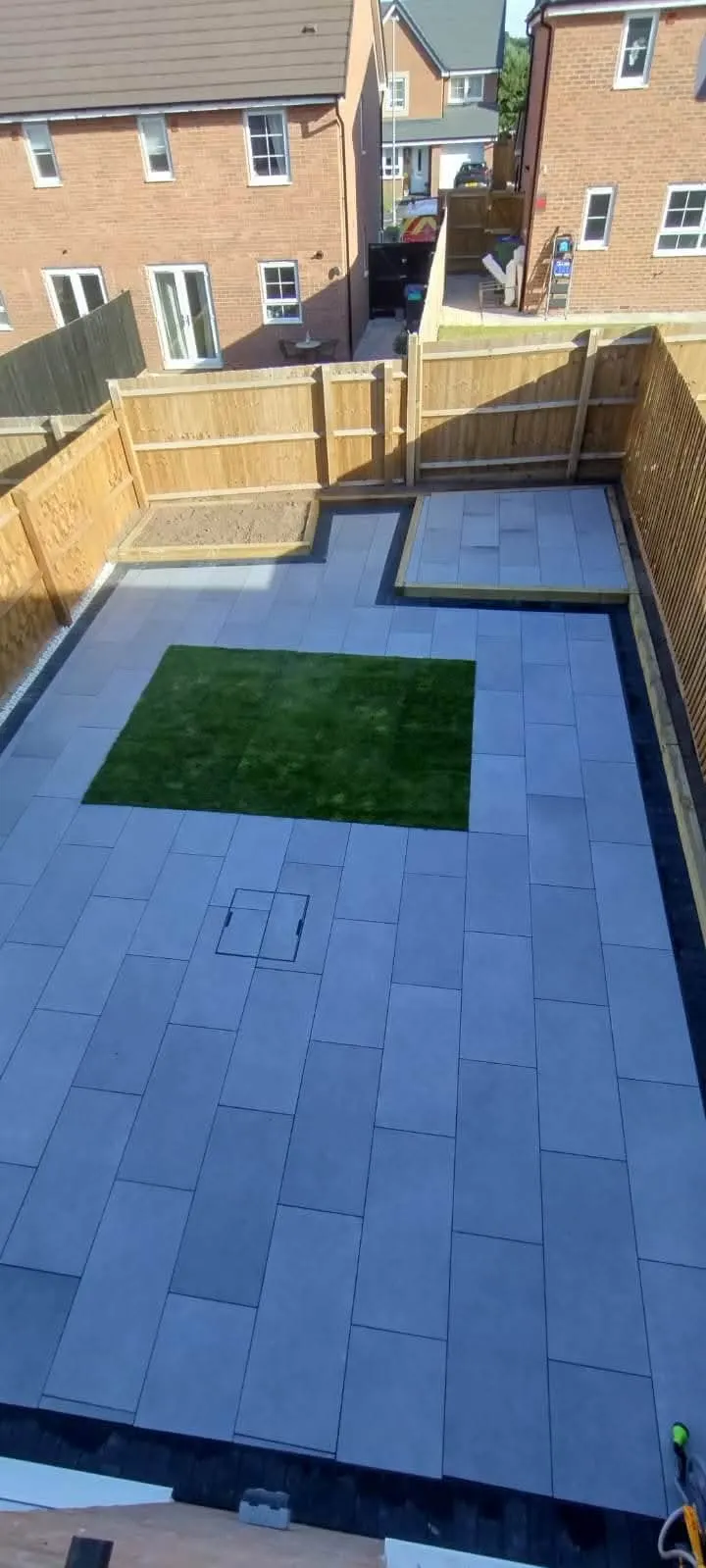 Grey porcelain patio with a square of artificial grass