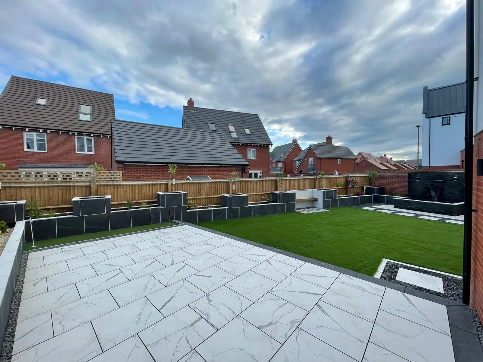 Grey porcelain patio with a charcoal border and lawn at a new-build
