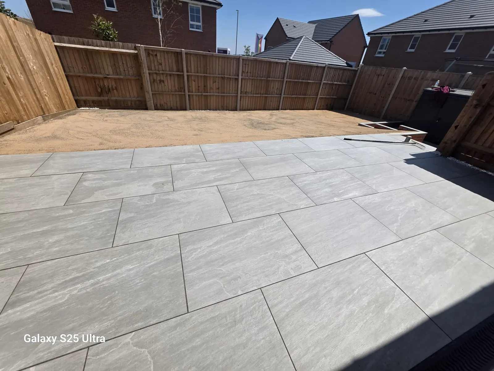 Grey porcelain patio in a fenced new-build garden
