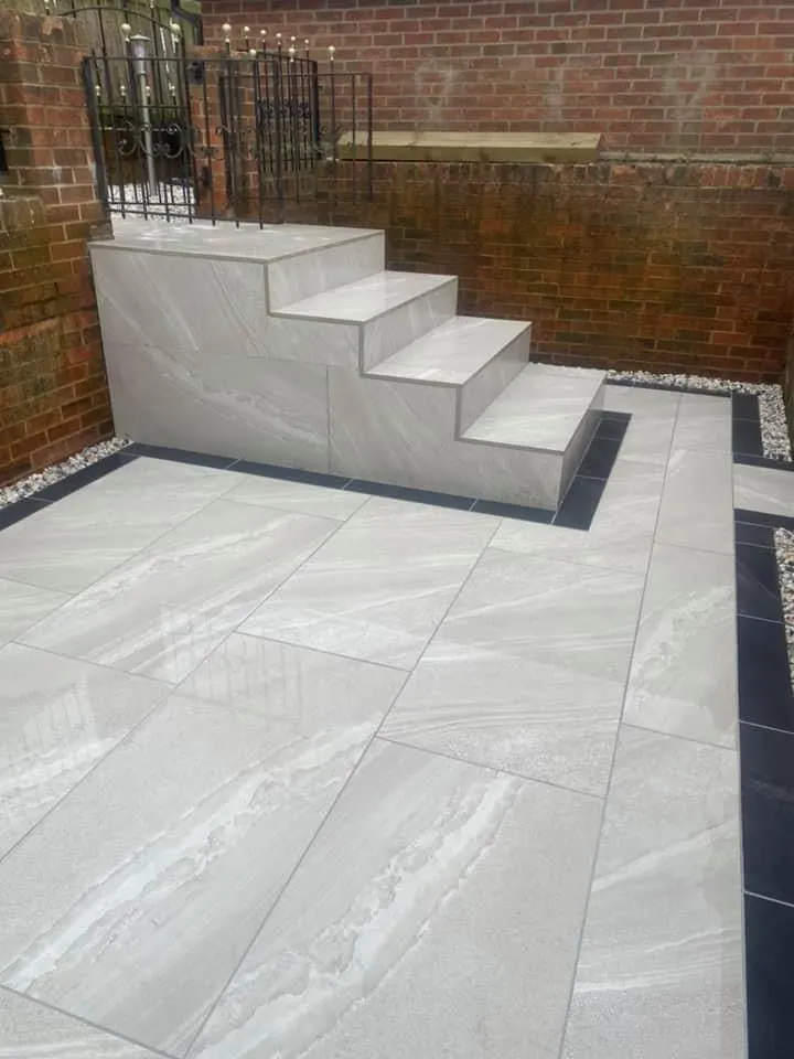Grey porcelain patio with rendered steps up to a raised level