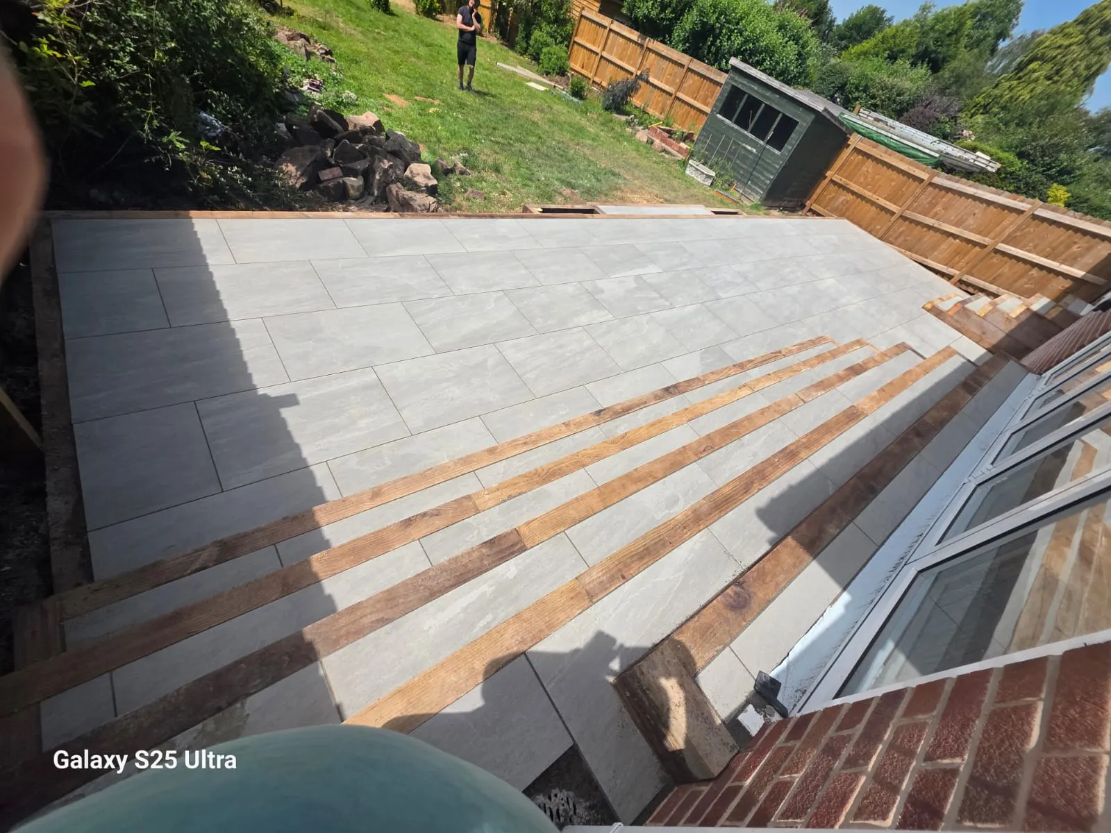 Grey porcelain patio with sleeper steps along bifold doors