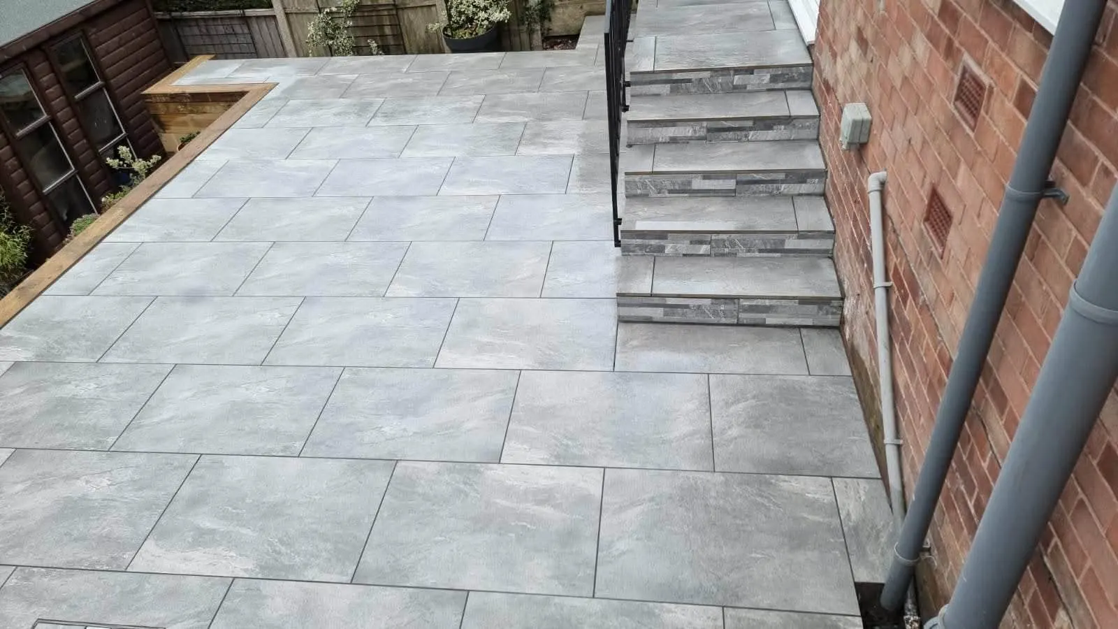 Grey porcelain patio with steps and a sleeper edge