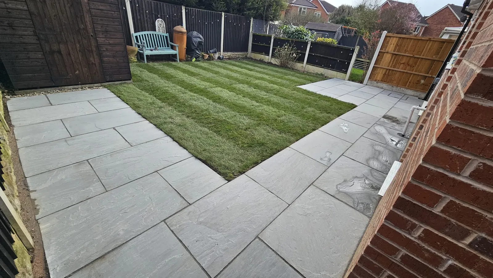 Grey porcelain patio round a newly turfed striped lawn