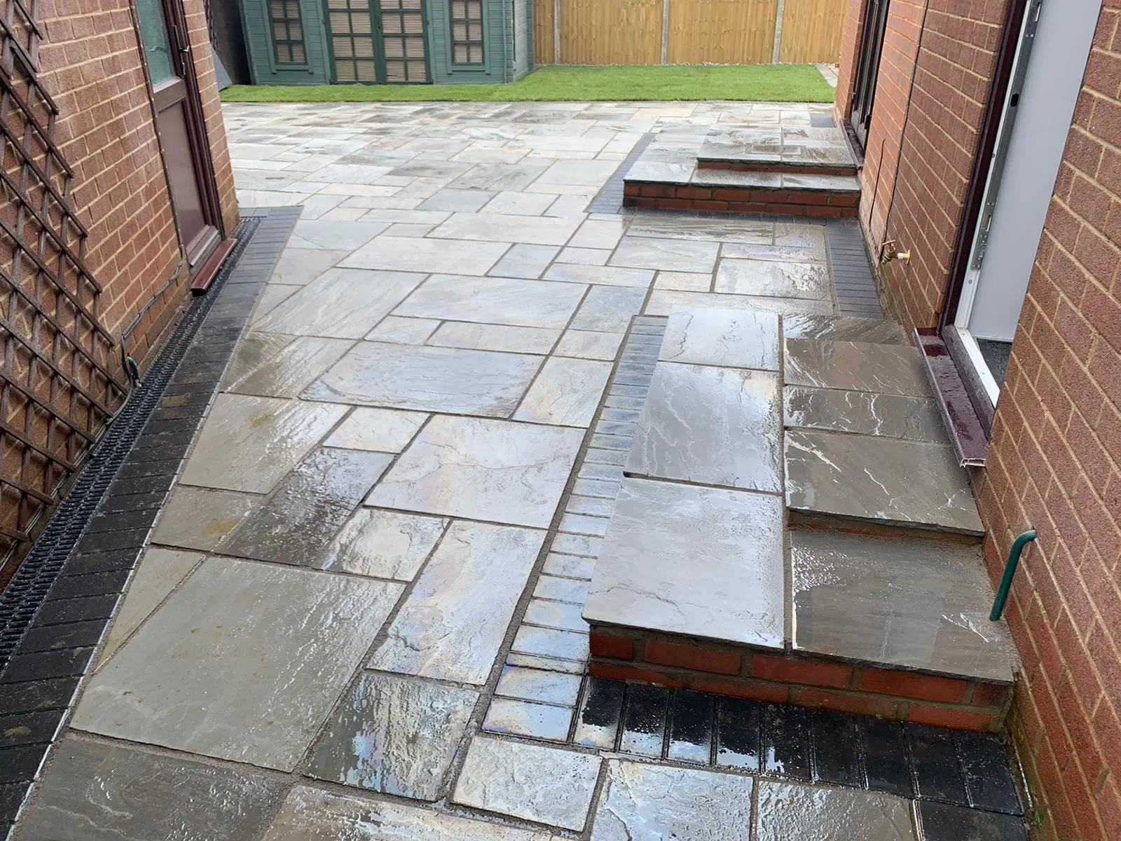 Grey sandstone patio and steps along a side return