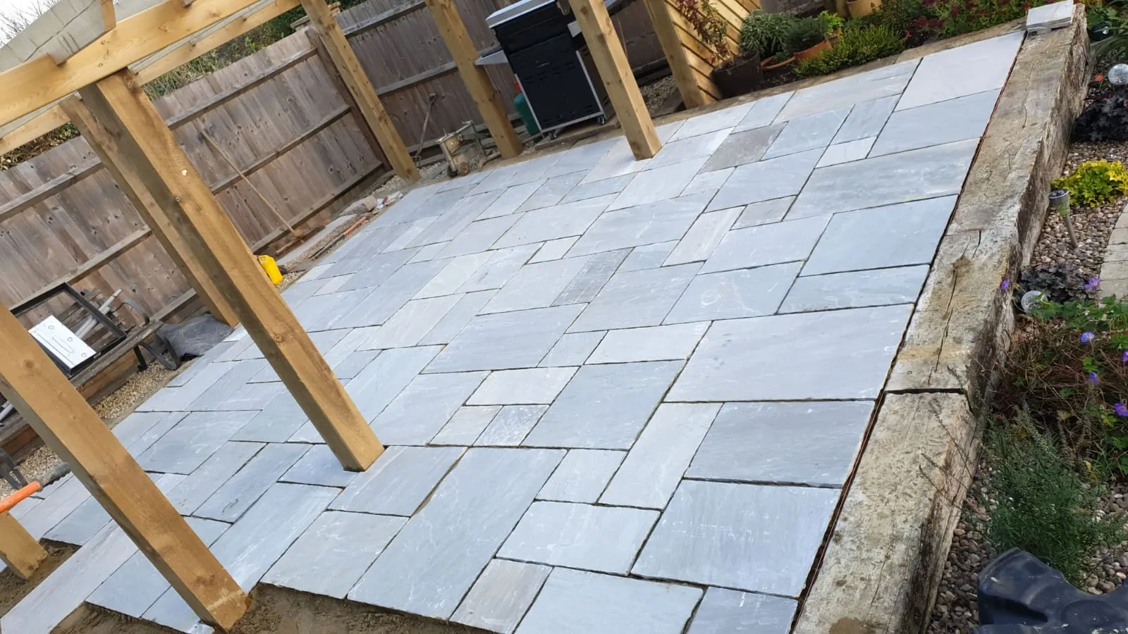 Grey sandstone patio under a timber pergola