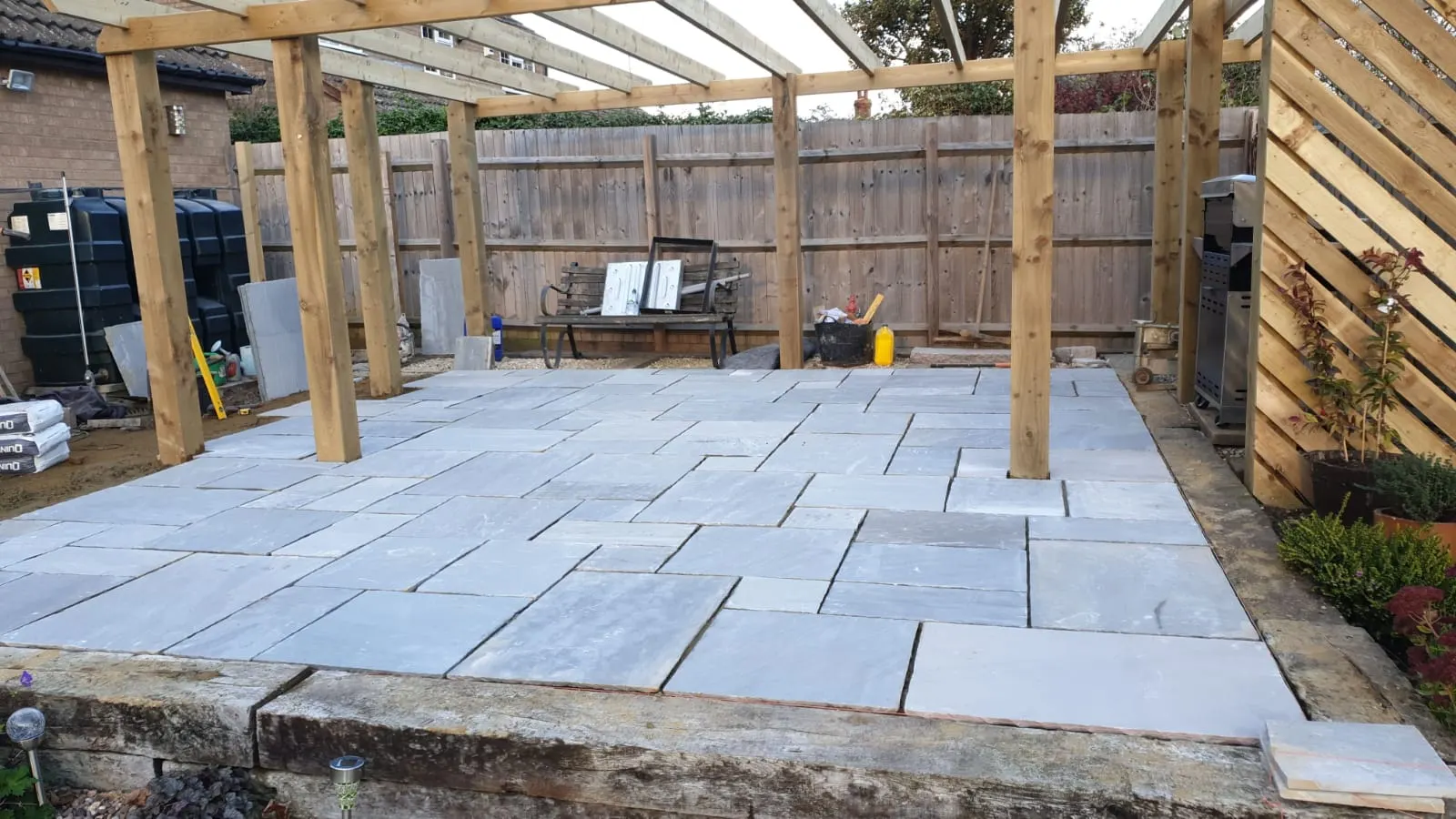 Grey sandstone patio laid under a pergola