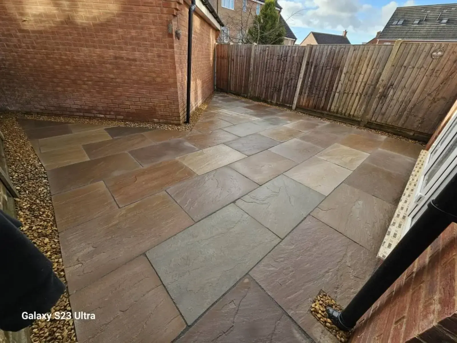 Indian sandstone patio in a walled side garden