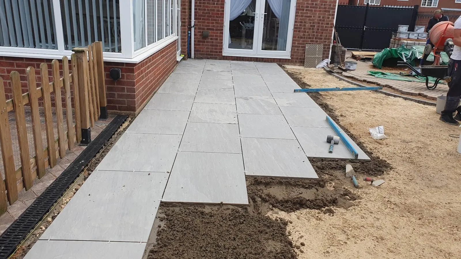 Light porcelain patio being laid on a mortar bed