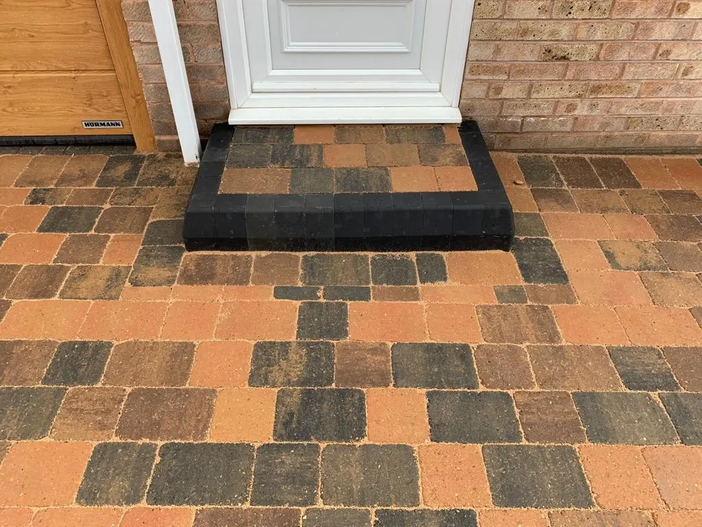 Multicolour block paving with a charcoal step at a front door