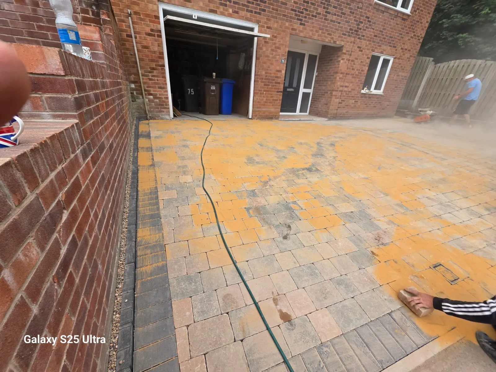 Multicolour block paving driveway beside a brick wall