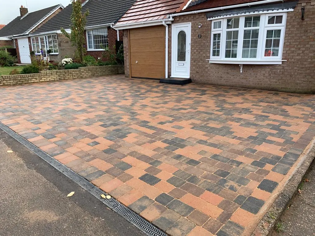 Multicolour block paving driveway with a channel drain at a bungalow